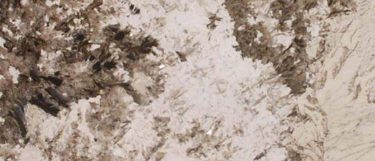 an Alpine White granite countertop surface that features brown flecks over the creamy white background