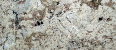 a white spring granite countertop with white, gray, and brown swirls and flecks on top of its warm white background