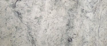 a siberian white granite countertop surface that has black flecks and gray wave veining over the white background