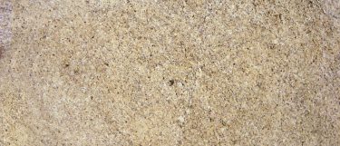 a New Venetian Gold granite countertop that features veining pattern of red, grays, and brown over its golden beige surface