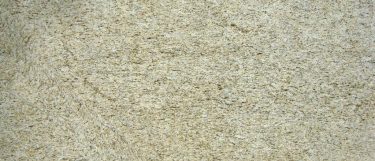 a Giallo Ornament granite countertop surface that features dark gray and brown veining design over the creamy white background