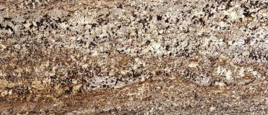 a Delicatus Gold granite countertop surface that has a snowflake-like pattern in gold, brown, black, cream, and white
