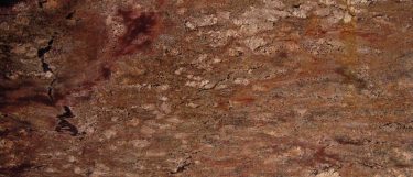 a Crema Bordeaux granite countertop surface that features shades of red earth tones with beige and gray fleck details