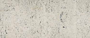 a Cotton White granite countertop surface that features speckles of tan and reddish black over the pale grayish white background