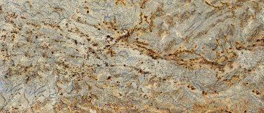 a Cobra granite countertop surface that features a swirling design in white and gold with thin veins and brown speckles