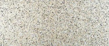 a Beidge Butterfly granite countertop surface that has colors of beige, cream, white, and black on a speckled pattern