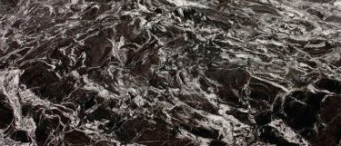 an Arabian Nights granite countertop surface that features white and gold veining over the black background