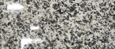 a valle nevado granite countertop surface that has flecks of white, gray, and taupe with black specks