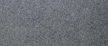 a Luna Pearl granite countertop surface that features pattern of white, black, gray, brown, and cream small speckles