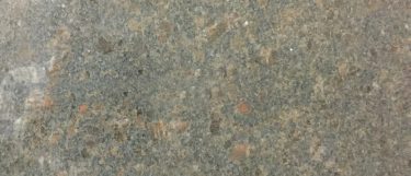 a coffee brown granite countertop surface that has a reddish black background with dark brown details