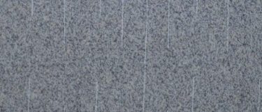 a Blanco Espana granite countertop surface that features light gray and white colors in a grainy design with white vertical linear streaks