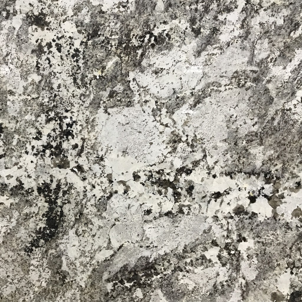 an Alaska White granite countertop surface that features a design that has a frosty blend of silver and white with warm neutral hues