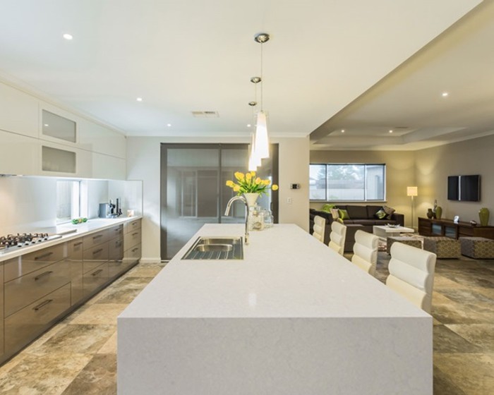 gioia_carrara_3 an elegant kitchen with pendant lightings, white cabinets, and waterfall Gioia Carrara countertops and kitchen island
