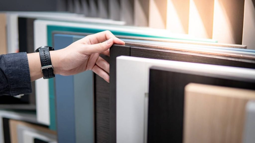 a man choosing cabinet panel materials or countertops in varying colors and designs