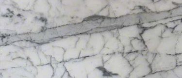 a Statueritto marble countertop that has think and thick veining over the white marble surface