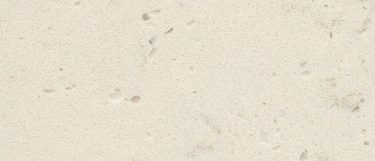 a vortium quartz countertop surface that has a light cream hue with dark speckles