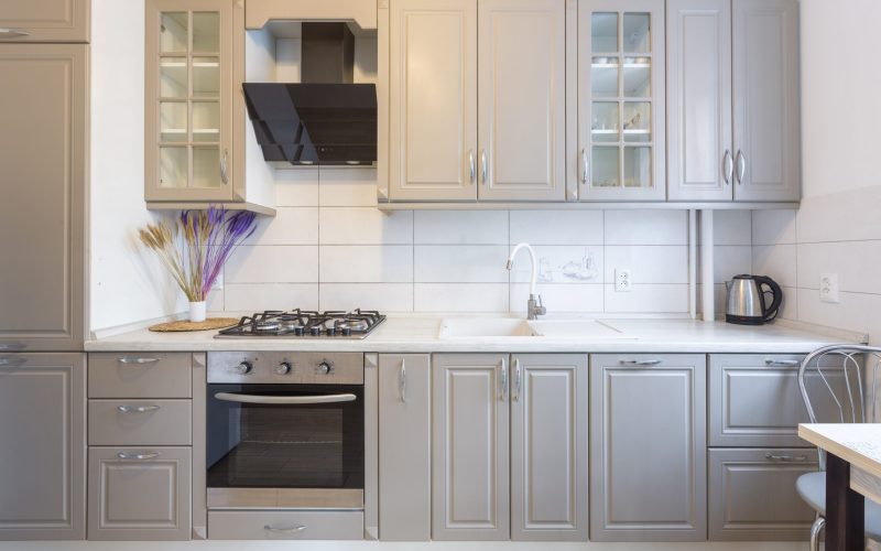 Interior of a modern beige and gray kitchen in a small smart apartment